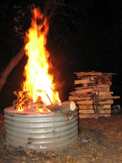Notice the 5-foot-high stack of firewood pallets beyond the campfire.
